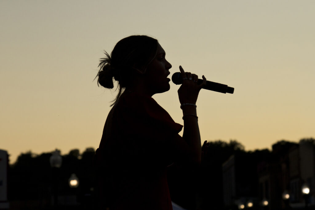 The silhouette of Ally Grande singing at WaterFire Sharon, Pa, July 27, 2024